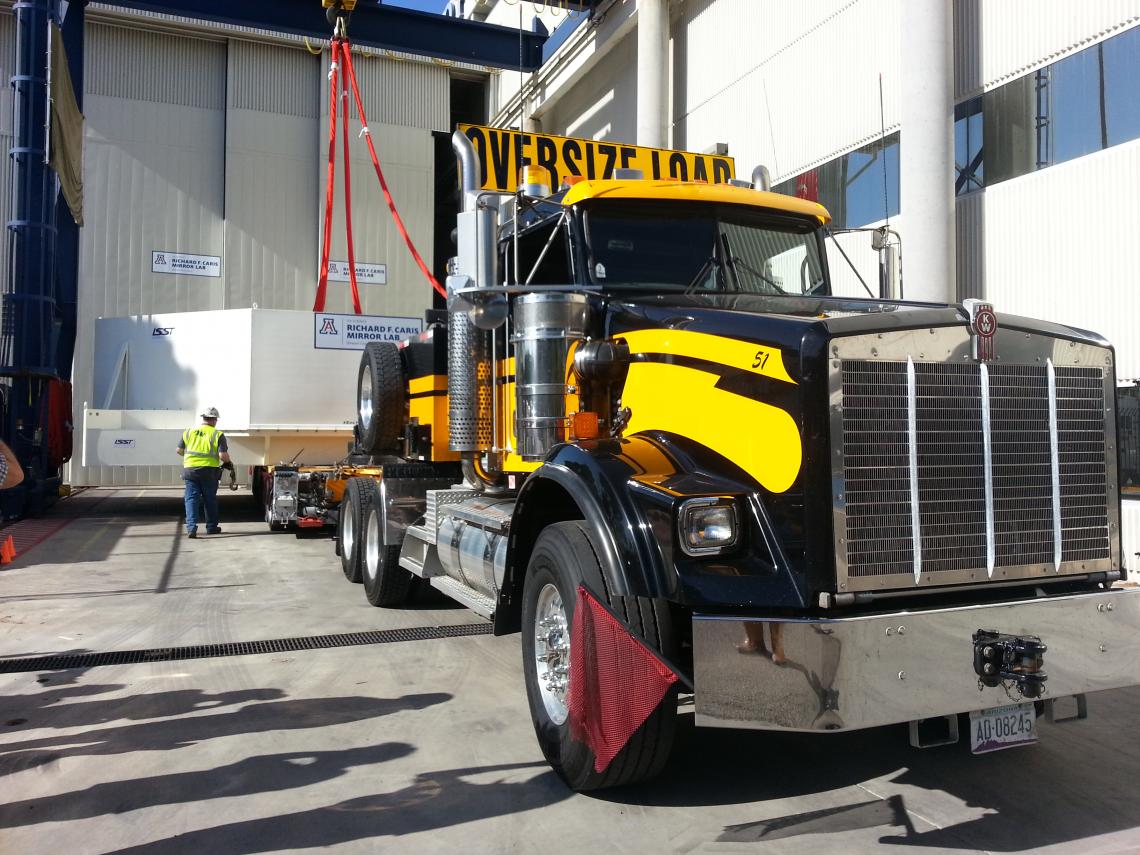 Tucked inside a protective case, the LSST mirror is lowered onto a flatbed trailer to be hauled off to temporary storage. Tucked inside a protective case, the LSST mirror is lowered onto a flatbed trailer to be hauled off to temporary storage.
